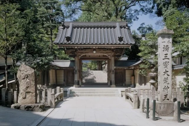 清荒神清澄寺の山門。瓦屋根と木の柱、奥へ続く石段