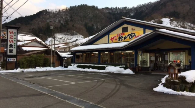 青い屋根と黄色い壁のいこい食堂、手前の駐車区画。企業紹介掲載写真・撮影時期不明