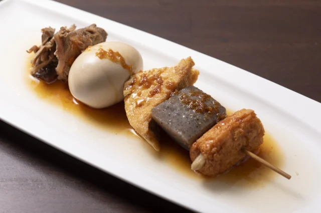 灘菊かっぱ亭の大串黒おでん。卵やこんにゃくなどを通した串と生姜醤油