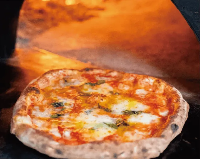 参加店PIZZERIA HIROの紹介に掲載された、薄い生地に焼き目がついたピザの写真