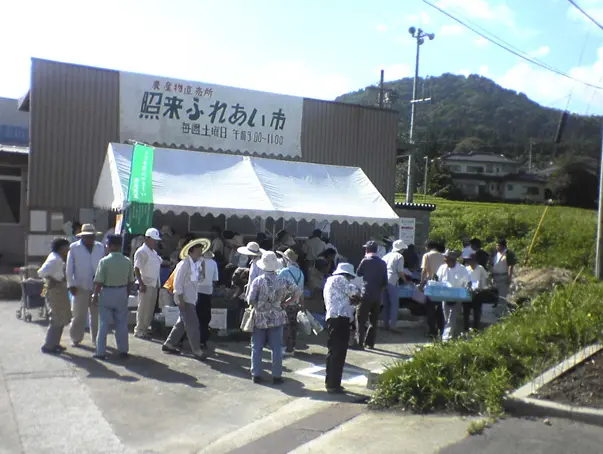 白いテントの下で販売する照来ふれあい市。町掲載の写真で撮影年不明
