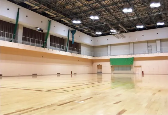 施設公式のサブアリーナ写真。高い梁の天井、白い壁と競技用ラインのある木の床。