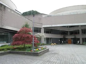 但東分館公式ページの庁舎中庭と入口。淡い色の屋根と灰色の外壁が見える