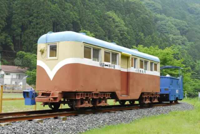 一円電車くろがね号のクリーム色と赤茶色の客車、青い機関車