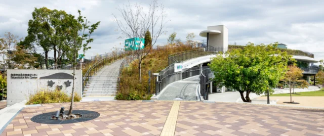 宝塚市立文化芸術センターの外観。植栽のある屋上と階段、右側のスロープ